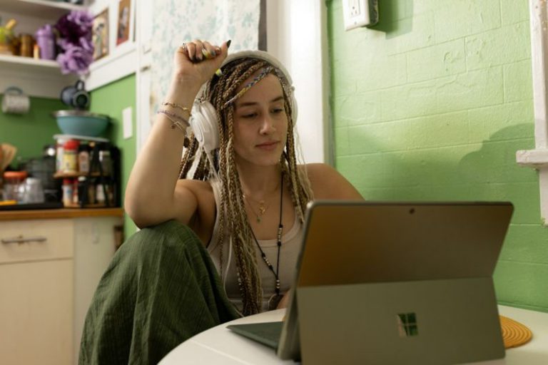Student Cultural Center Belgrade - a woman with dreadlocks sitting in front of a laptop computer
