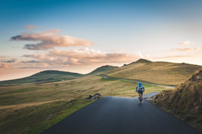 Belgrade Cycling - person cycling on road distance with mountain during daytime