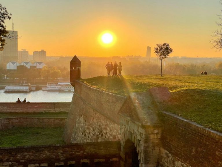 Belgrade Fortress - a group of people standing on top of a grass covered field