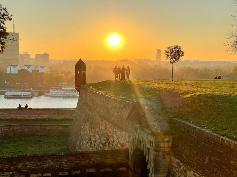Belgrade Fortress - a group of people standing on top of a grass covered field