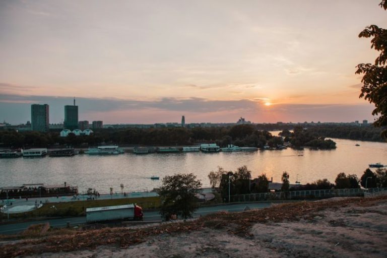 Old Town Belgrade - body of water near city buildings during sunset