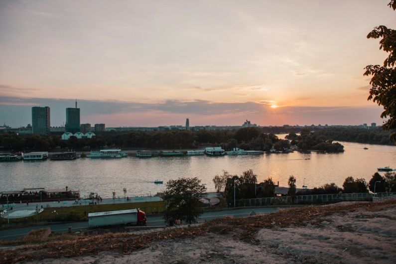 Old Town Belgrade - body of water near city buildings during sunset