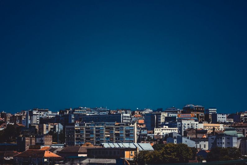 Royal Compound Belgrade - a view of a city with a plane flying in the sky