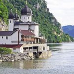 River Cruise - White and Black House Located at Riverside on Mountain Slope at Daytime