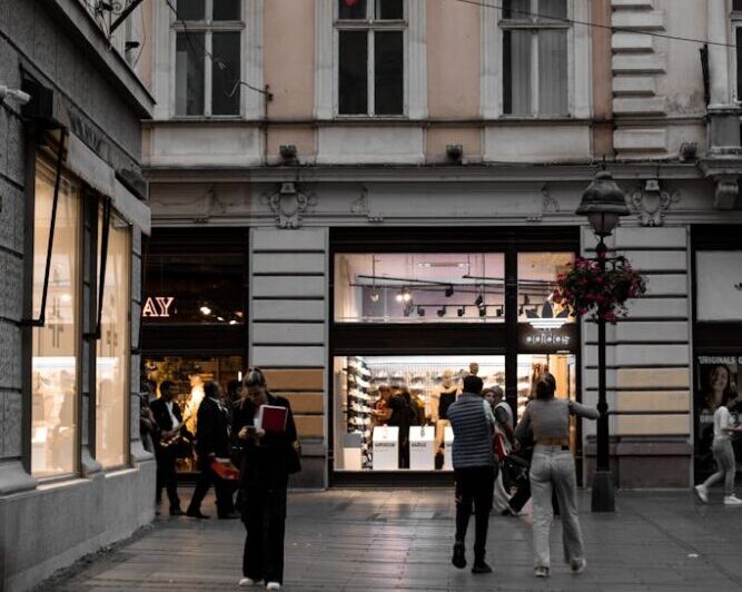 A lively street in Belgrade featuring a Spanish flag and historic architecture.