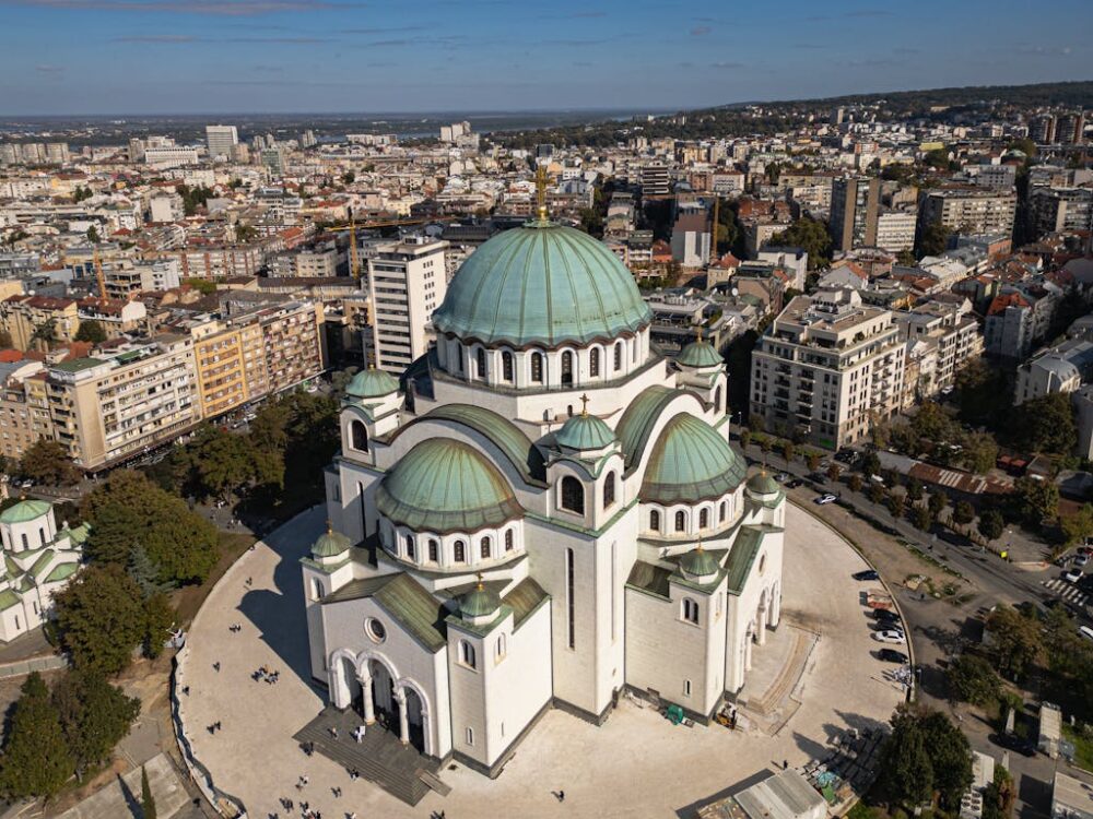 Aerial photography showcasing the grandeur of St. Sava Temple in Belgrade, Serbia against the city's urban landscape.