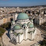 Aerial photography showcasing the grandeur of St. Sava Temple in Belgrade, Serbia against the city's urban landscape.