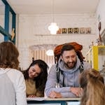 Backpackers cheerfully checking in at a vibrant hostel reception desk.