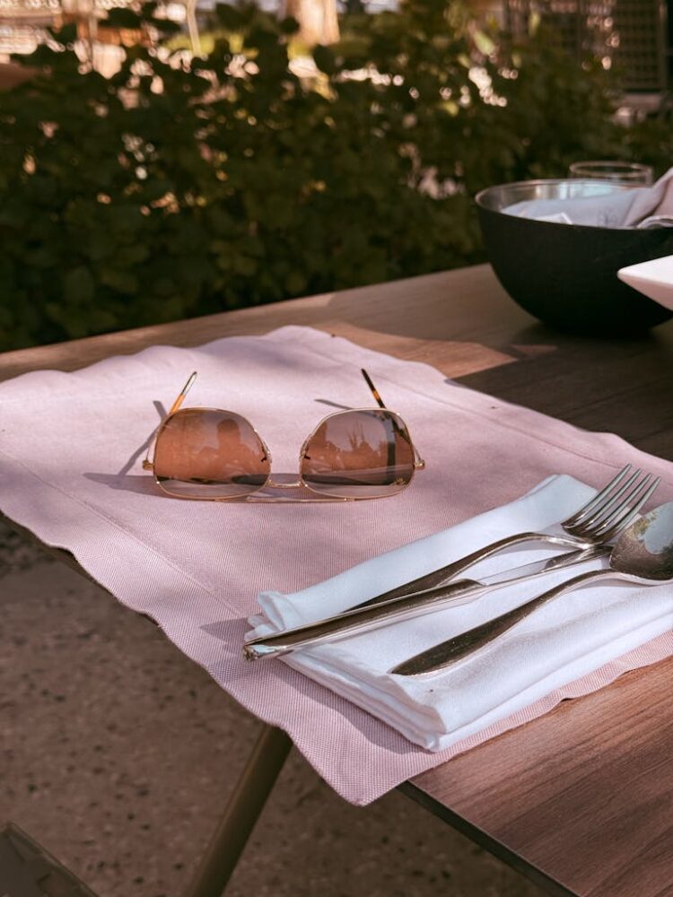 Chic outdoor table setting with sunglasses, perfect for summer vibes.
