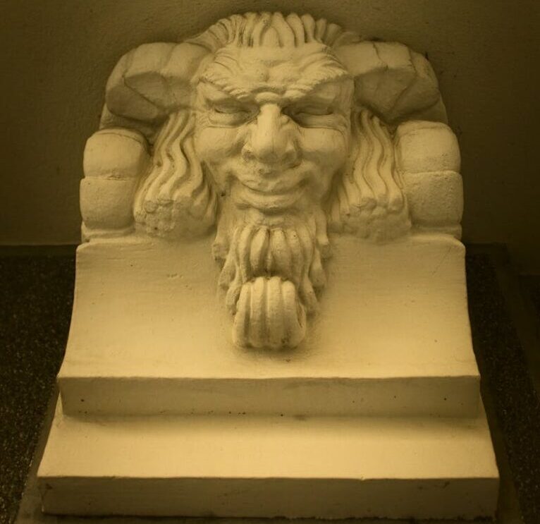 Detailed stone carving of a mythical face, a striking museum exhibit in Belgrade, Serbia.