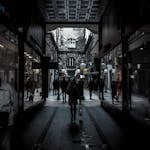 Moody alleyway in Belgrade's historic district with silhouettes of people walking, offering a glimpse of urban life.