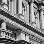 Neoclassical building facade with columns in Belgrade, Serbia captured in black and white.