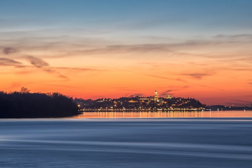 Serene sunrise view of Kalemegdan Fortress reflected on the river in Belgrade, Serbia.