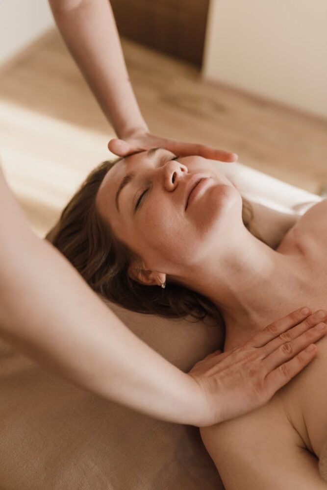 Woman receiving a soothing facial massage in a wellness spa setting for relaxation.