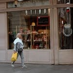 Woman walking past a Stark store in Belgrade, Serbia. Captures the urban shopping vibe.