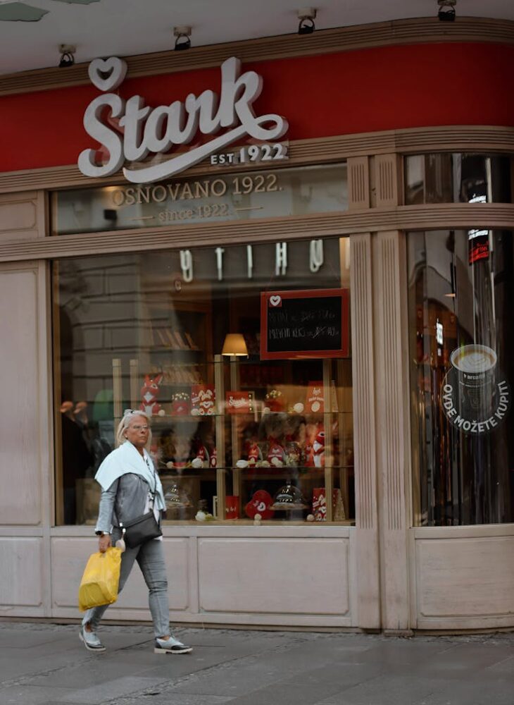 Woman walking past a Stark store in Belgrade, Serbia. Captures the urban shopping vibe.